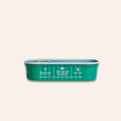 Green pet food can with white text on a beige background