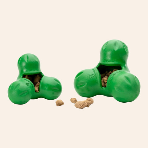 Green dog toy with treats inside on a white background