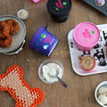 Magic Mix baking mix containers on a wooden surface with baked goods and ingredients.