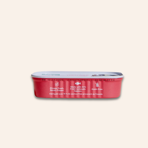 Red can of pet food with white label on a light pink background