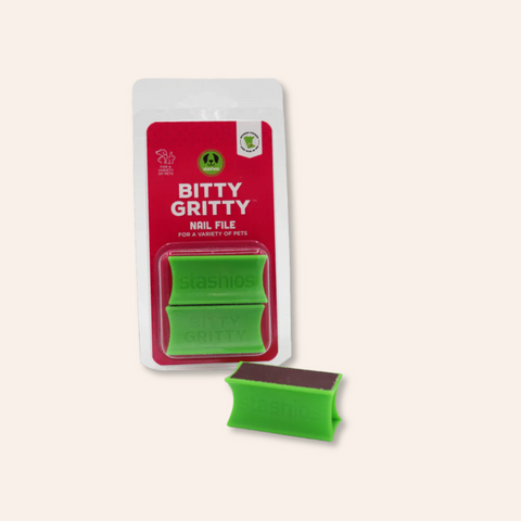 Green pet nail file with red packaging labeled 'Bitty Gritty' on a beige background