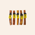 Five dog bully chew sticks with yellow labels on a beige background